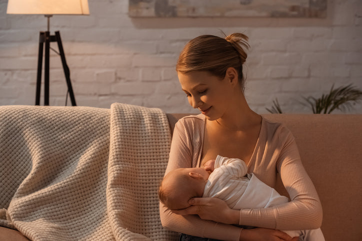 mother breastfeeding baby comfortably in cozy home environment