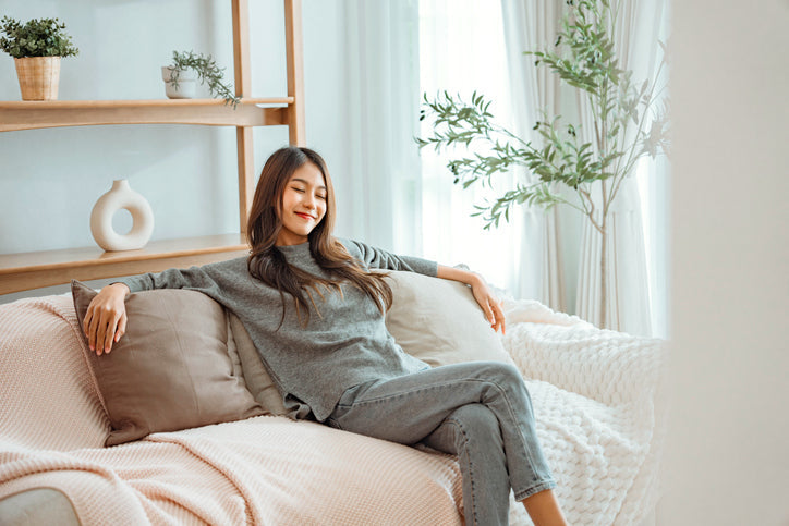Woman relaxing on a sofa in a bright living room