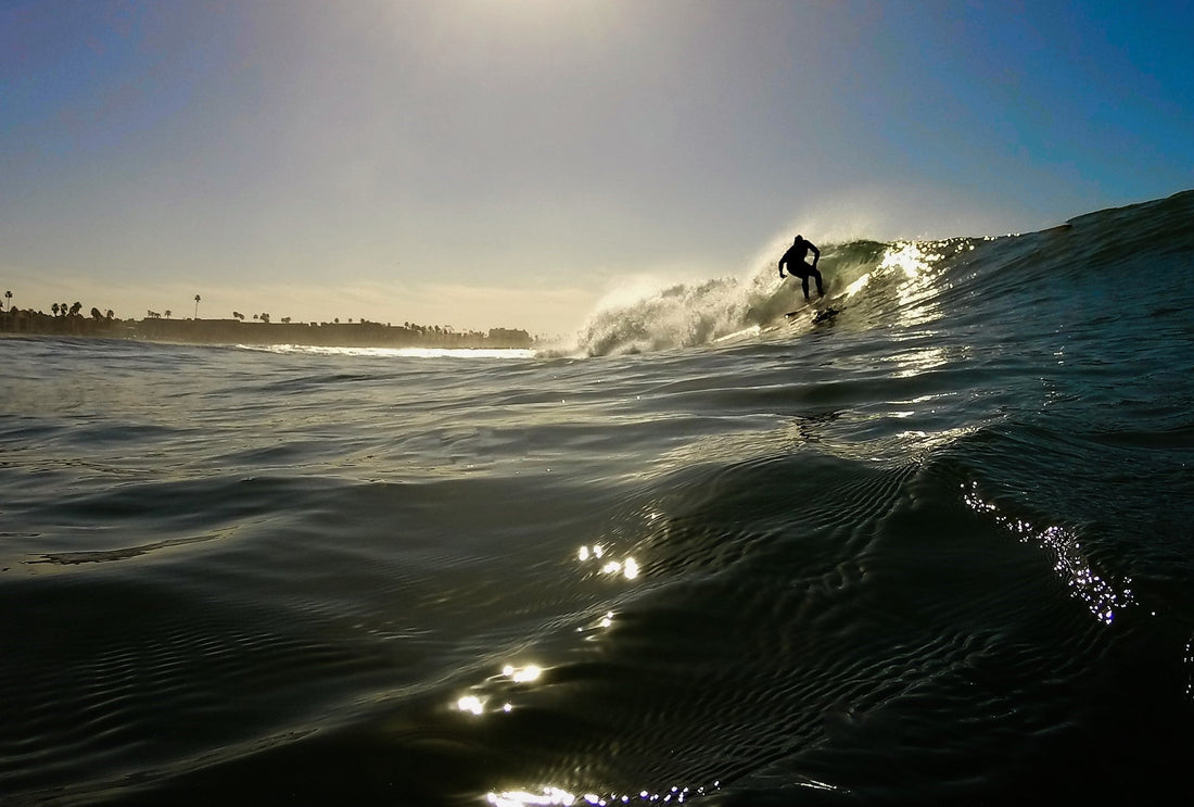 surfers paddling in ocean under sunlight with boards